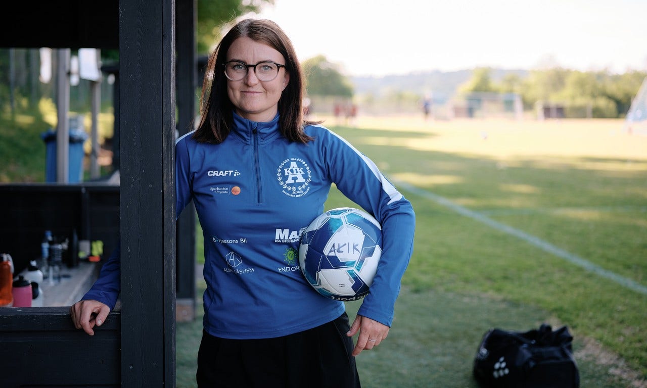 En kvinna som håller en fotboll under armen
