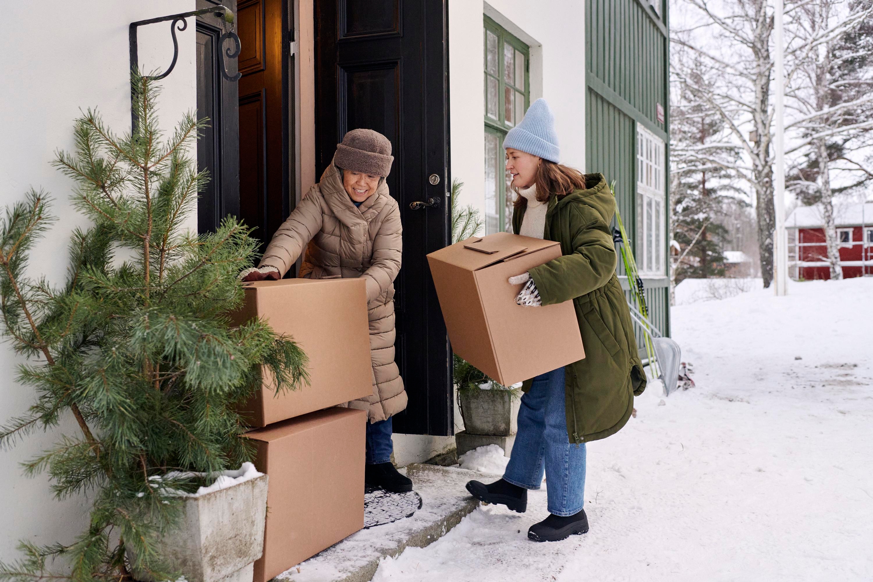 Två kvinnor bär flyttkartonger