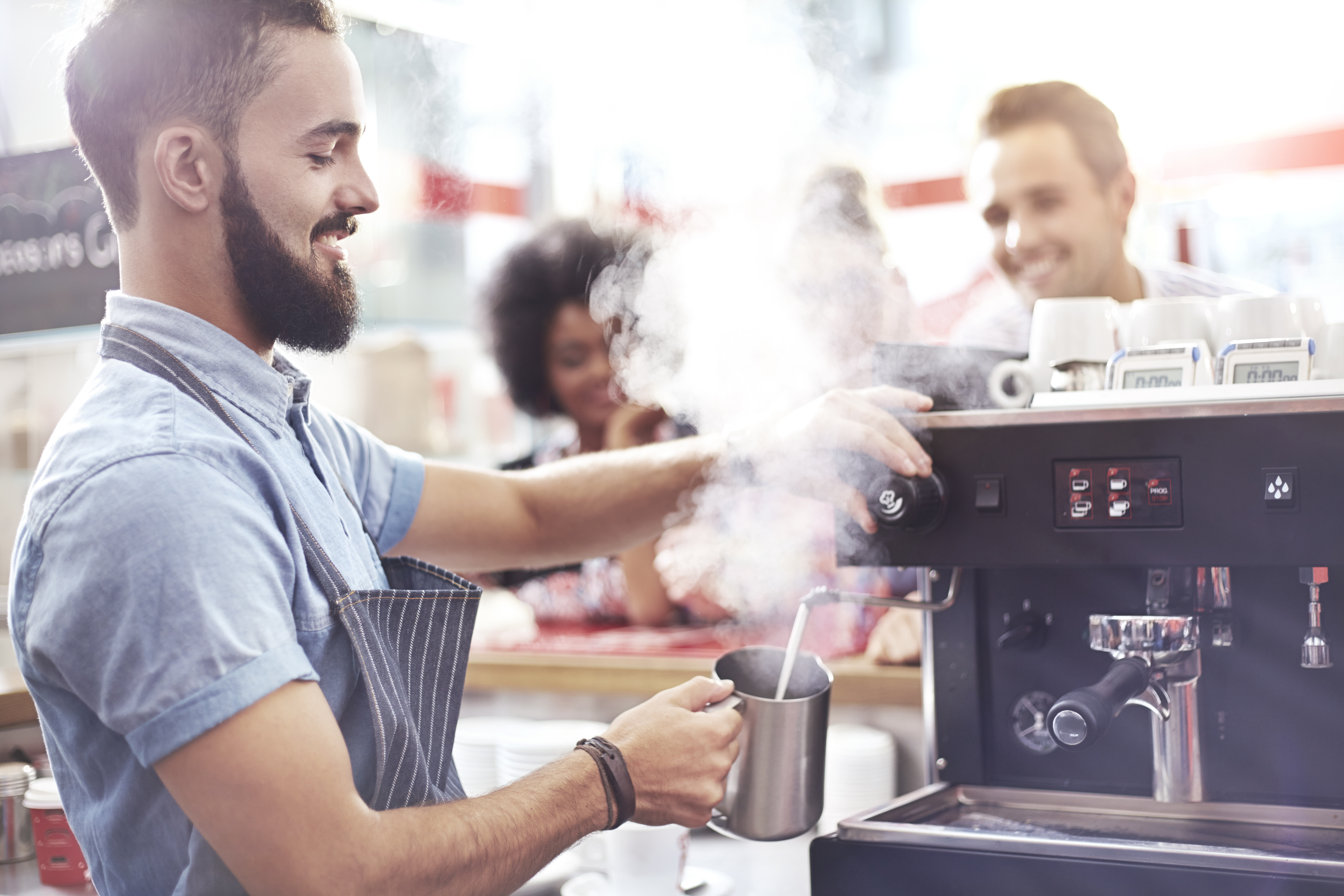 Leende barista gör kaffe på ett café