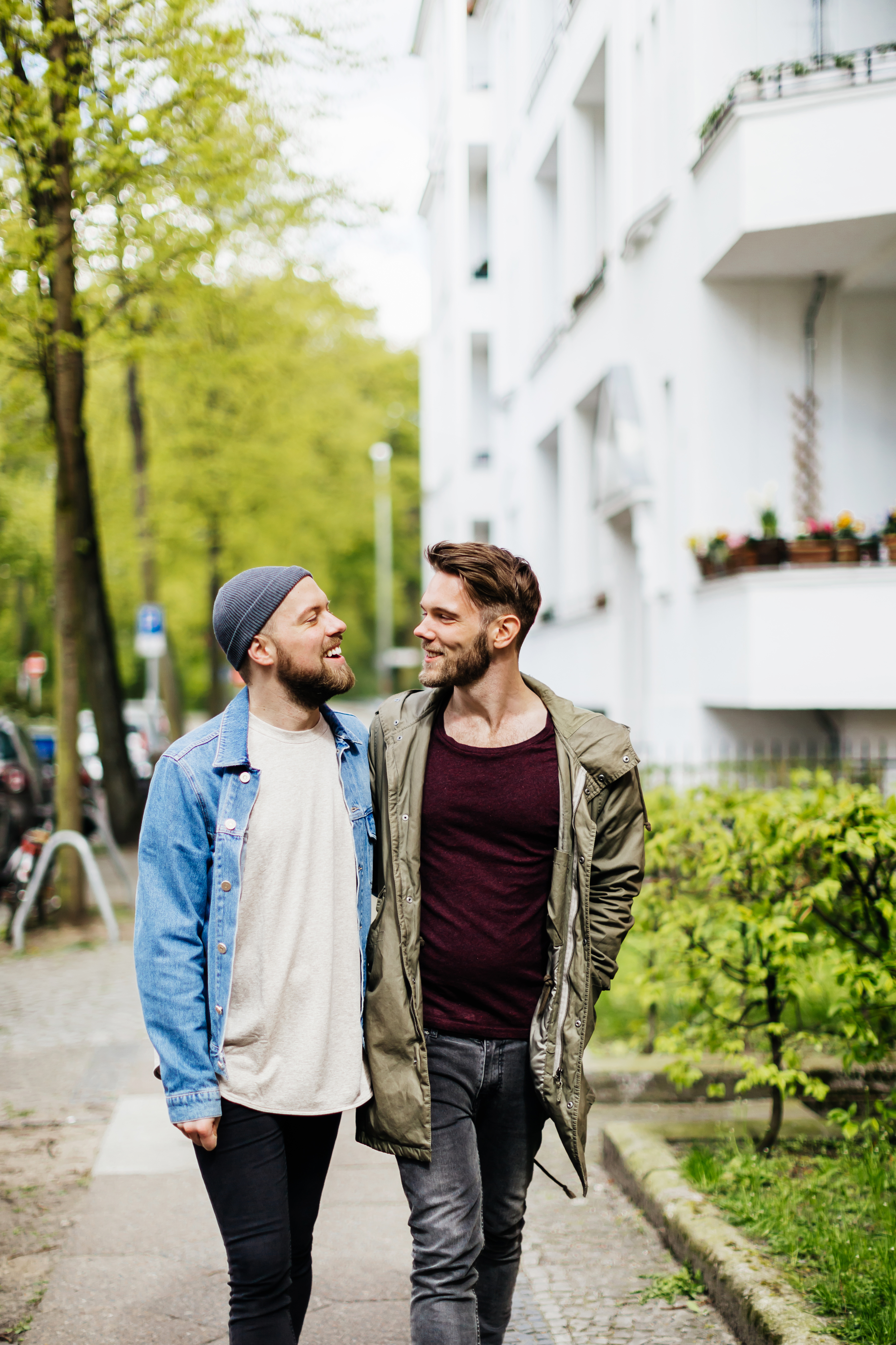 Två män går på gatan, håller om varandra och ler