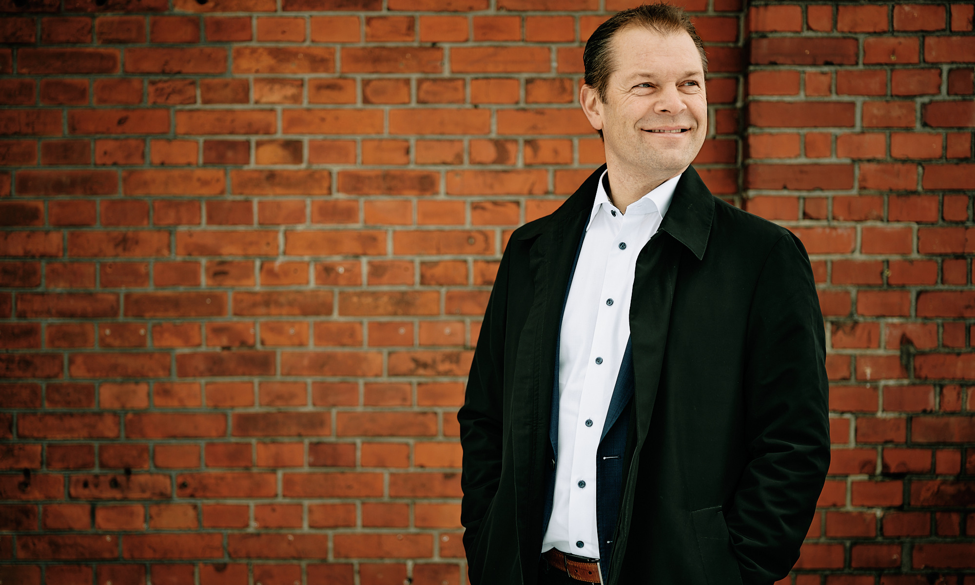 Man in front of a brock wall