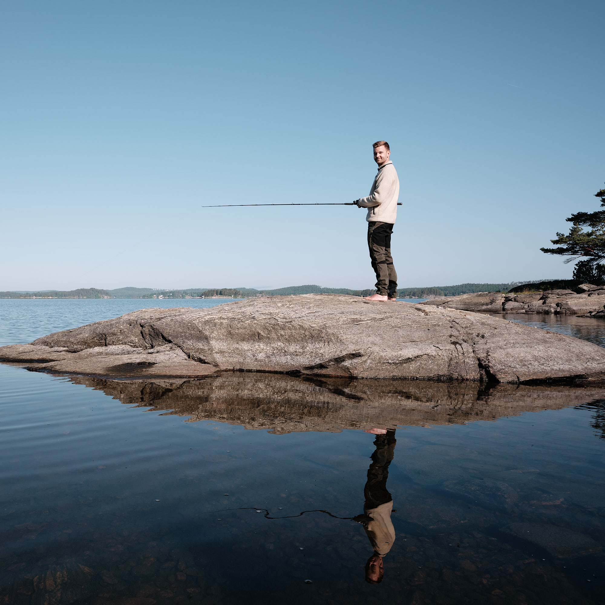 Man holding fishing rod by the lake 
