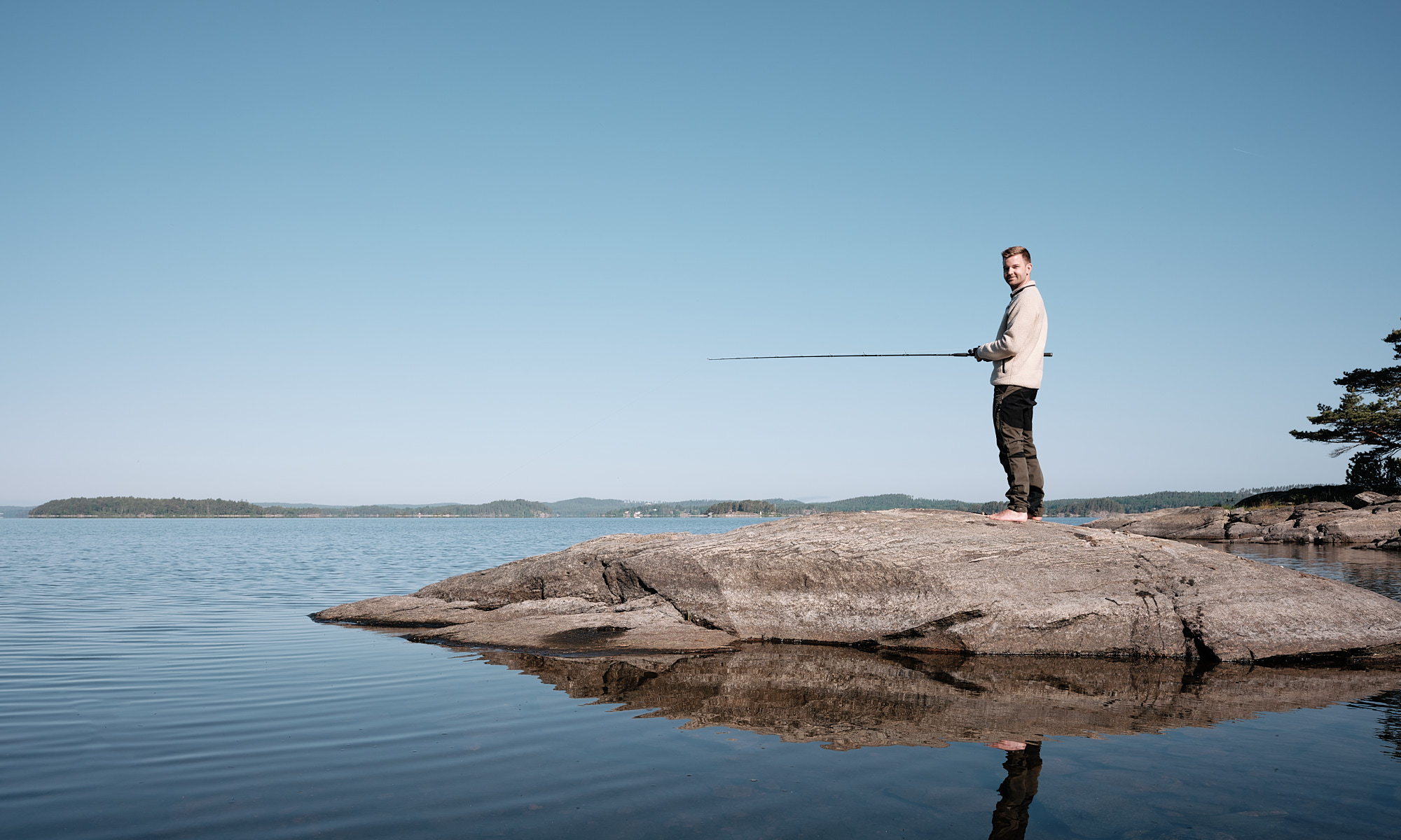 Man holding fishing rod by the lake 