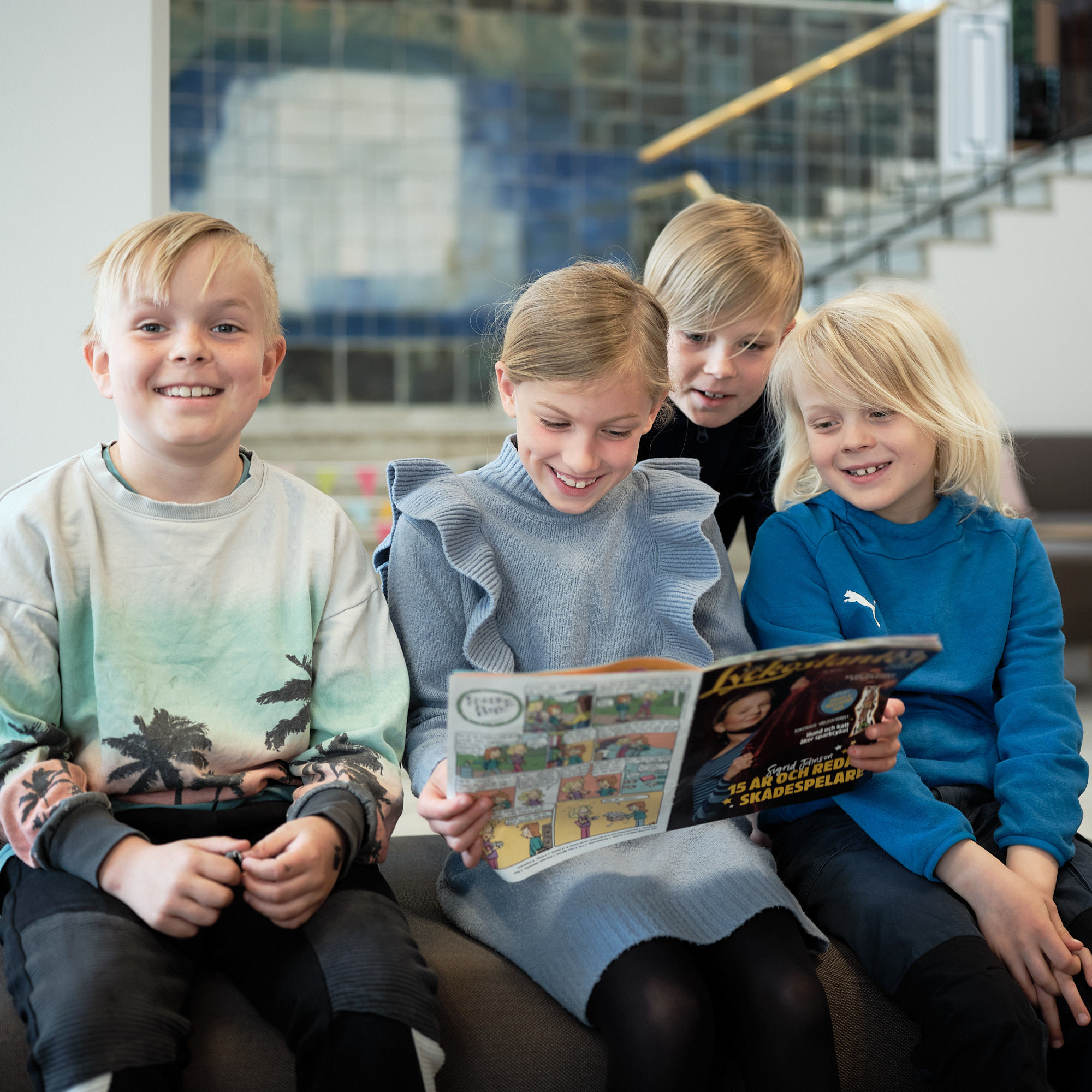 Fyra barn som läser en tidning tillsammans