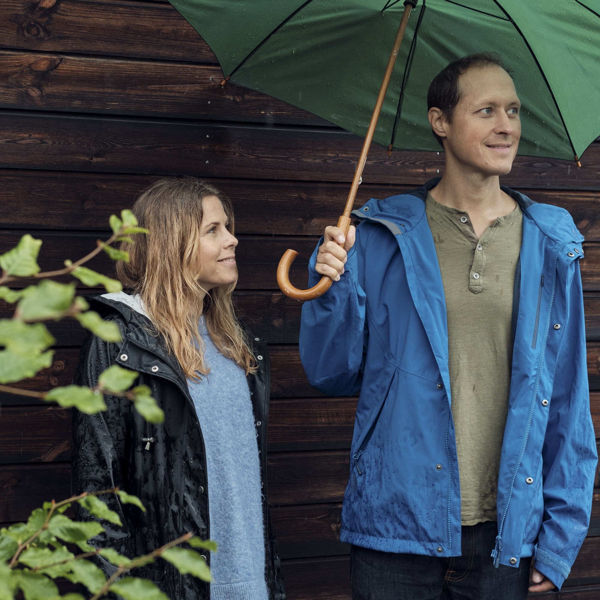 Man och kvinna med ett paraply i regnet