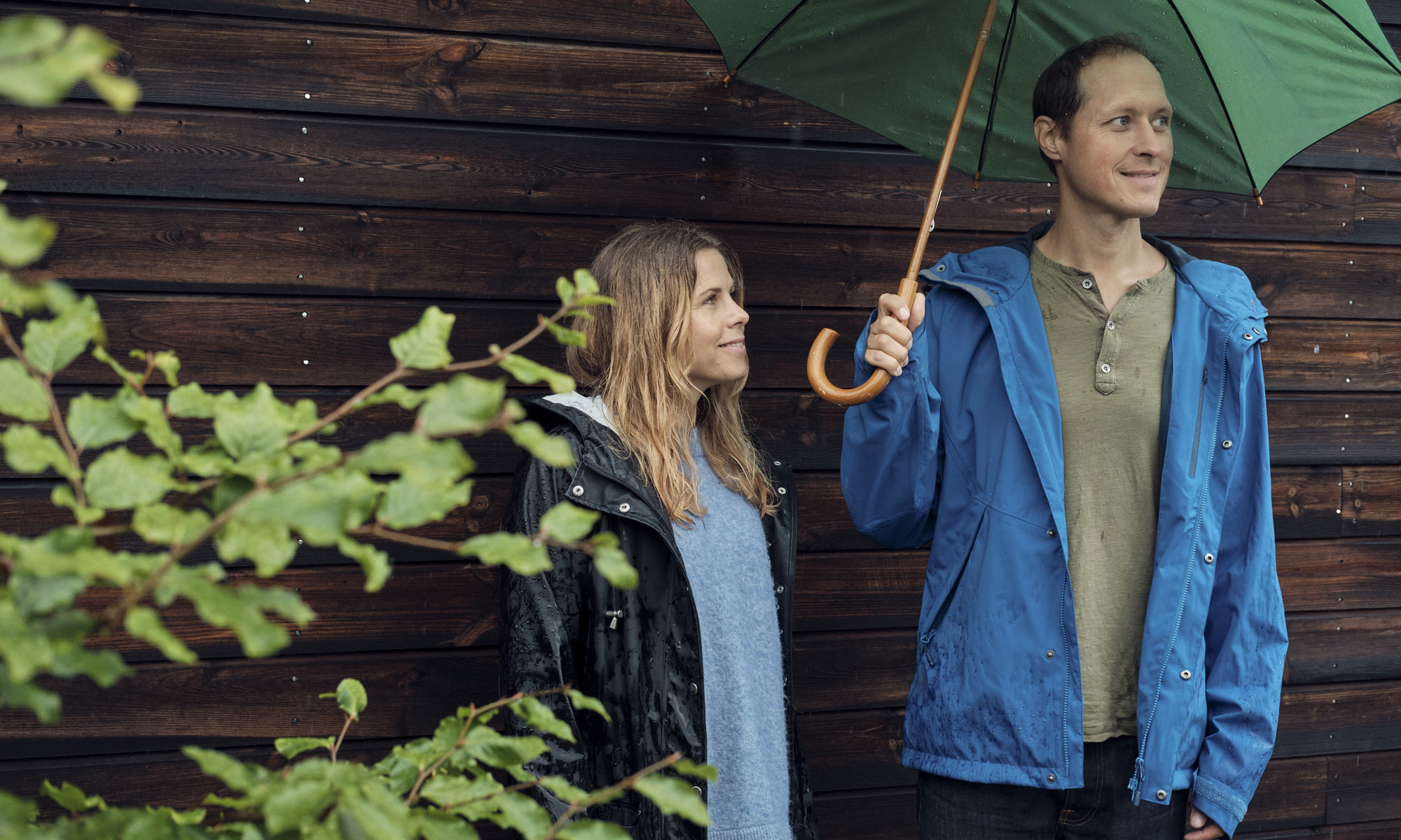 Man och kvinna med ett paraply i regnet