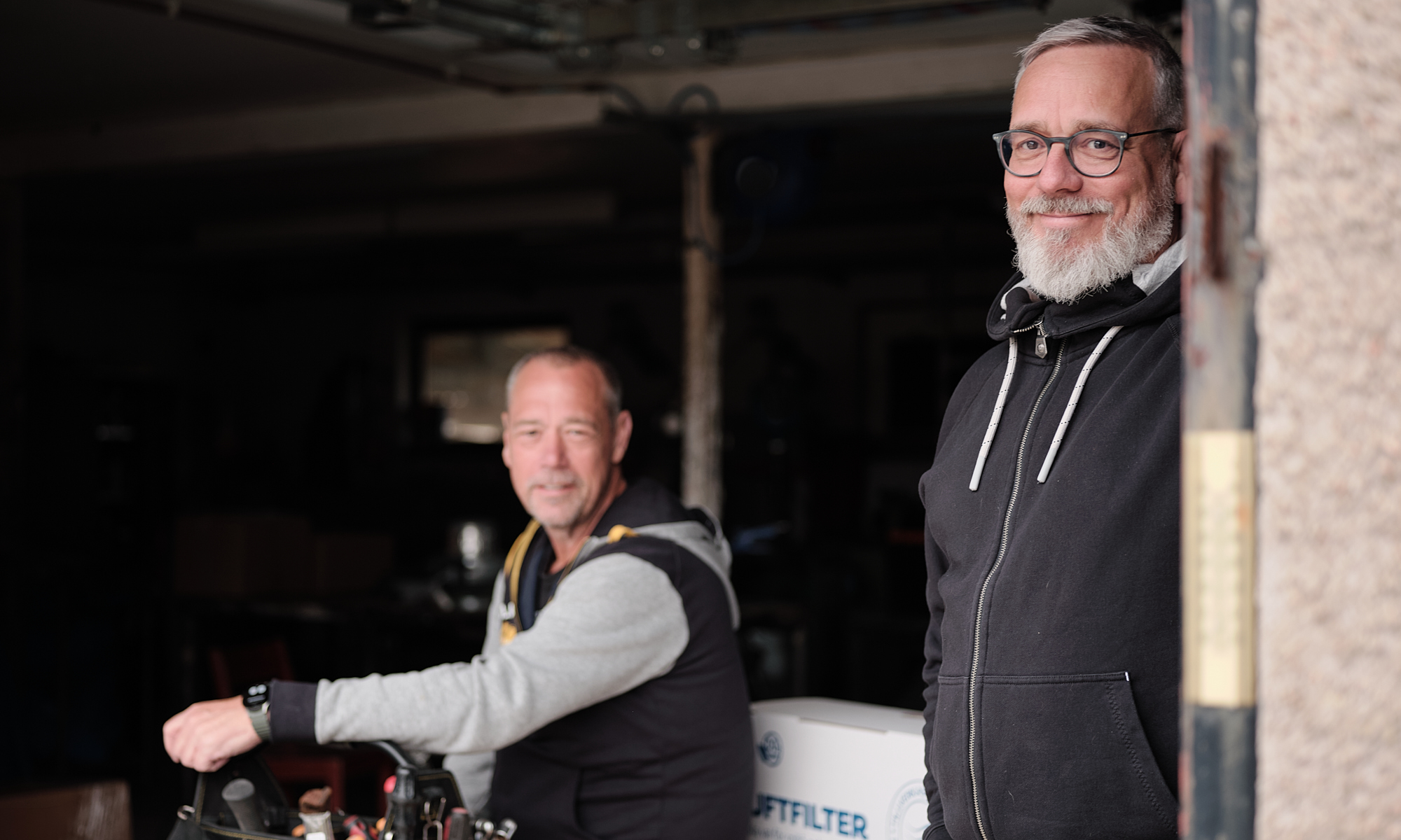 two men in a garage 