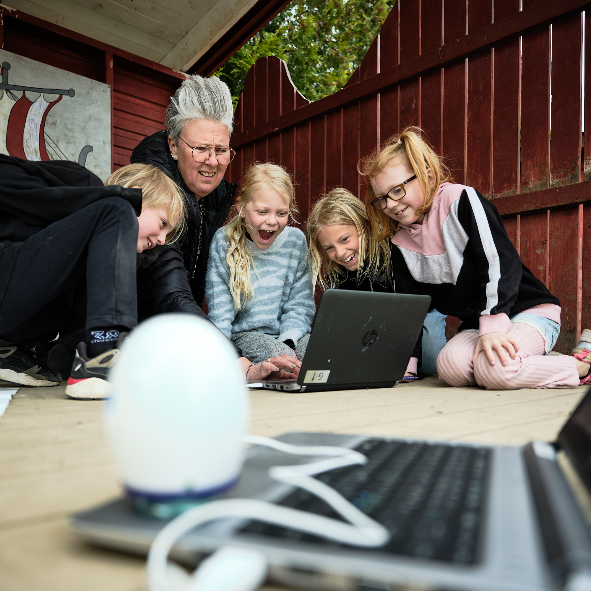 Eb grupp elever med sin lärare som tittar på något spännande på en skärm