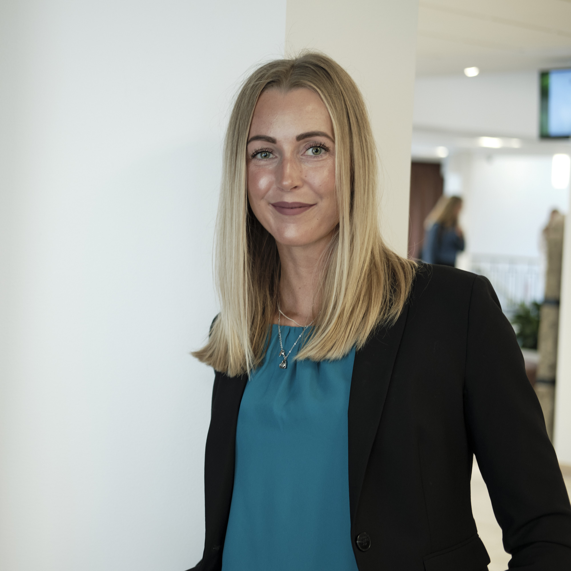 Jurist Amande lunande mot en vägg, tittar in i kameran
